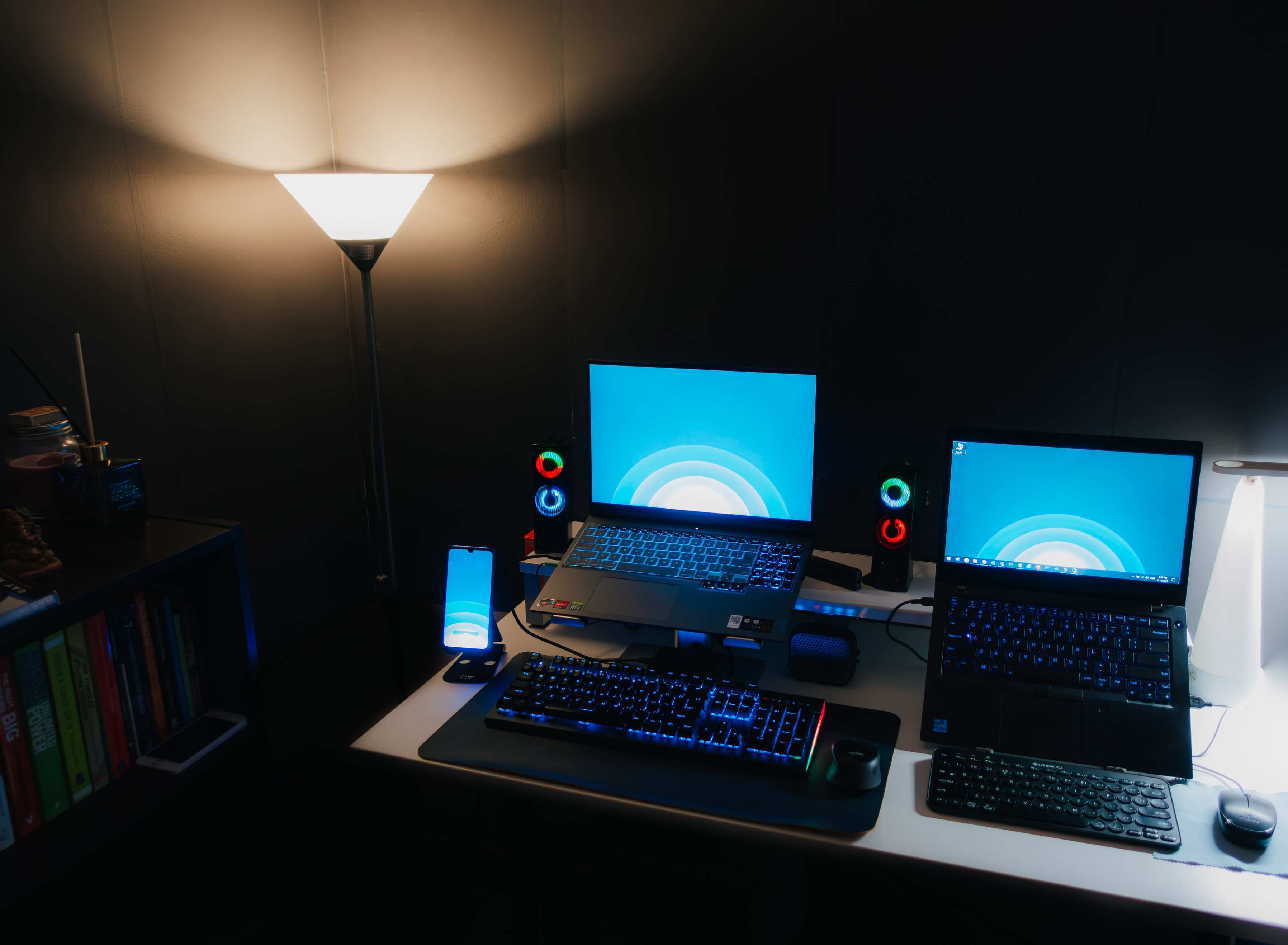 Programming workstation with laptop and monitor, nighttime office desk setup with laptops